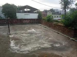 A 2-story building with 4 shops and vacant land beside it, total 4.32 Katha.